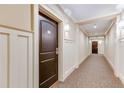 Well-lit hallway with paneled walls and carpeting leading to apartment door at 2277 Peachtree Ne Rd # 608, Atlanta, GA 30309