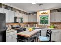 Well-lit kitchen featuring granite countertops, white cabinets, an island, and stainless steel appliances at 12040 Old Mountain Park Rd, Roswell, GA 30075