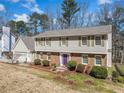Inviting home featuring brick and siding exterior, complemented by green shutters and a vibrant purple front door at 1532 Boxwood Nw Trce, Acworth, GA 30102