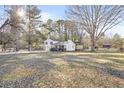 A split-level home with a large yard, mature trees, and a wooden deck at 916 Marshall Fuller Rd, Dallas, GA 30157