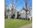Charming two-story home with gray stucco siding, a landscaped lawn, and mature trees in a desirable neighborhood at 610 Coolsprings Ln, Woodstock, GA 30188