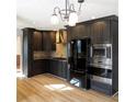 Well-equipped kitchen featuring stainless steel appliances, dark cabinets, and beautiful granite countertops at 610 Coolsprings Ln, Woodstock, GA 30188
