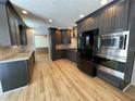Modern kitchen features stylish dark cabinets, stainless steel appliances, and a light wood floor at 610 Coolsprings Ln, Woodstock, GA 30188