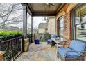 Cozy covered porch with wicker seating, glass table, stone floor, and a view of the neighborhood at 5340 Cole Creek Ln, Cumming, GA 30040