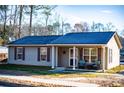 Inviting single-story house with covered porch featuring cozy seating and neat landscaping at 885 Green Valley Dr Nw, Conyers, GA 30012