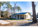 Quaint home featuring a cozy porch with seating, framed by mature trees and lawn at 885 Green Valley Dr Nw, Conyers, GA 30012