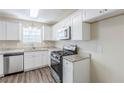 Modern kitchen featuring sleek white cabinets, stainless steel appliances, and granite countertops at 1908 Sailcloth St, Lithonia, GA 30058