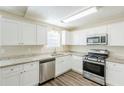 Bright kitchen featuring granite countertops, stainless steel appliances, and white cabinetry at 1908 Sailcloth St, Lithonia, GA 30058