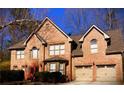 Charming two-story brick home featuring a well-maintained yard and an attached two-car garage at 709 Eastwood Rise, Stone Mountain, GA 30087