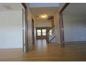 Inviting hallway featuring wood floors and staircase leading to the upper level of the home at 838 Roxholly Ln, Buford, GA 30518