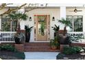 Inviting front entrance with a glass door, brick steps, and stylish potted plants at 1601 Marlbrook Ne Dr, Atlanta, GA 30307
