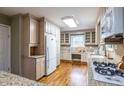 Well-lit kitchen with granite countertops, wooden cabinets, stainless steel appliances, and hardwood floors at 1881 Edinburgh Ne Ter, Atlanta, GA 30307