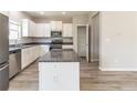 Bright kitchen featuring white cabinetry, granite countertops, stainless steel appliances, and an island with bar seating at 6399 Woodwell Dr, Union City, GA 30291