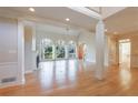 Bright living room featuring a fireplace, hardwood floors, large windows, and architectural columns at 1140 Matheson Way, Alpharetta, GA 30022