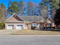 Charming single-story brick home featuring a two-car garage and well-manicured front yard at 3065 Kings Nw Dr, Kennesaw, GA 30144