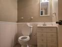 Cozy half bath featuring a toilet and vanity with a sink and mirror at 1840 Sw King Alfred Sw Dr, Atlanta, GA 30331
