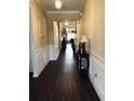Hallway featuring hardwood floors, wainscoting, neutral paint, and ample lighting throughout at 1061 Towne Mill Xing, Canton, GA 30114