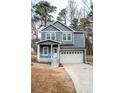 Two-story home featuring a driveway, garage, and charming front porch at 113 Miller Rd, Stockbridge, GA 30281