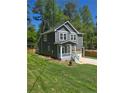 Beautiful two-story home with gray siding, white trim, and a charming covered front porch at 113 Miller Rd, Stockbridge, GA 30281