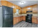 Kitchen featuring wooden cabinets, laminate countertops and black appliances at 4342 Lincolndale Dr, Ellenwood, GA 30294