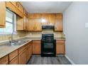 Well-lit kitchen with wooden cabinets, laminate countertops and black appliances at 4342 Lincolndale Dr, Ellenwood, GA 30294