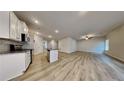Bright, open-concept living space with durable wood-look flooring, stainless steel appliances, and ample natural light at 11894 Brightside Pkwy, Hampton, GA 30228
