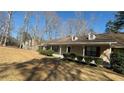 Ranch-style home featuring a covered porch, dormer windows and mature front yard landscaping at 440 Ward Rd, Ellenwood, GA 30294