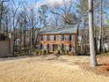 Charming brick home featuring blue shutters and a well-maintained front yard surrounded by mature trees at 505 Summer Ter, Woodstock, GA 30189