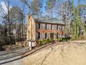 Traditional two-story home with brick facade, blue shutters, and mature trees at 505 Summer Ter, Woodstock, GA 30189
