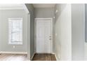 View of the entryway with wood floors, a window with blinds and a white six-panel door at 202 Nathan Sw Rd, Atlanta, GA 30331