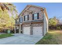 Beautiful two-story home featuring a brick facade, attached two-car garage, and manicured lawn at 2154 Dodson Woods Dr, Fairburn, GA 30213