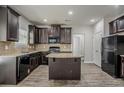 Modern kitchen with dark wood cabinets, granite countertops, and stainless steel appliances at 2154 Dodson Woods Dr, Fairburn, GA 30213