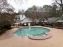 Community pool with attached spa, surrounded by a black metal fence at 6051 Wintergreen Rd, Norcross, GA 30093