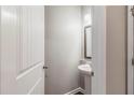 A half bathroom features a pedestal sink, stylish mirror, and classic white woodwork at 811 Lake Chase, Fairburn, GA 30213