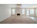Spacious living room with a cozy fireplace, plush carpeting, and abundant natural light at 104 Shadow Creek Ct, Fairburn, GA 30213
