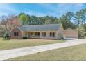 Ranch-style home featuring a two-car garage, a long driveway, and a well manicured lawn at 110 Eastfield Ct, Mcdonough, GA 30252
