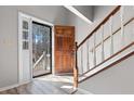 Bright foyer with wood-look floors, showcasing a staircase and beautiful wood front door with sidelight at 108 Kelly Ct, Dallas, GA 30157