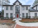 Elegant brick home with a prominent arched window above the front door, complemented by manicured landscaping at 4880 Hunters Oaks Ln, Alpharetta, GA 30009