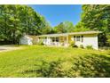 Well-maintained home with a detached garage and green lawn, surrounded by mature trees and lovely landscape at 5115 Cascade Palmetto Hwy, Fairburn, GA 30213