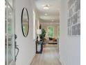 Inviting hallway with a modern mirror, light walls, and views into the open living space at 112 Winsome Way, Woodstock, GA 30188