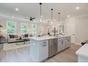 Bright, open kitchen with stainless steel appliances, island with sink, and views into the living room at 112 Winsome Way, Woodstock, GA 30188