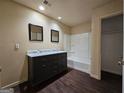 Bathroom with double sink vanity, framed mirrors and a tub with shower at 3053 Herscu Way, Stonecrest, GA 30038