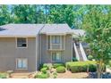 Exterior view of a two-story condo featuring a gray facade, multiple windows and mature trees at 2937 Torreya Way, Marietta, GA 30067