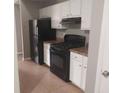 Efficient kitchen with black appliances, white cabinetry, and durable countertops for easy maintenance at 4952 Isle Royal Ct, Stone Mountain, GA 30088