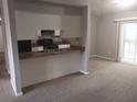Open-concept living space featuring carpet flooring, a breakfast bar, and sliding glass door access to the outside at 4952 Isle Royal Ct, Stone Mountain, GA 30088