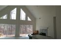 Bright living room featuring high ceilings, large windows with scenic views, and a fireplace at 8155 Stone Hill Rd, Cumming, GA 30028
