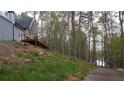 View of home with yard and path through mature trees leading to a lake at 8155 Stone Hill Rd, Cumming, GA 30028