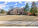 A well-maintained brick house features a lush green lawn and mature trees at 2046 Chambord Way, Snellville, GA 30078
