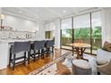 Open living space featuring a bar area, wooden table and large windows that bring nature inside at 2575 Peachtree Ne Rd # 8D, Atlanta, GA 30305