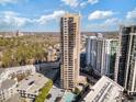 Stunning aerial view of a high-rise building with balconies, a pool, parking, and city views under a partly cloudy sky at 3481 Lakeside Ne Dr # 2303, Atlanta, GA 30326